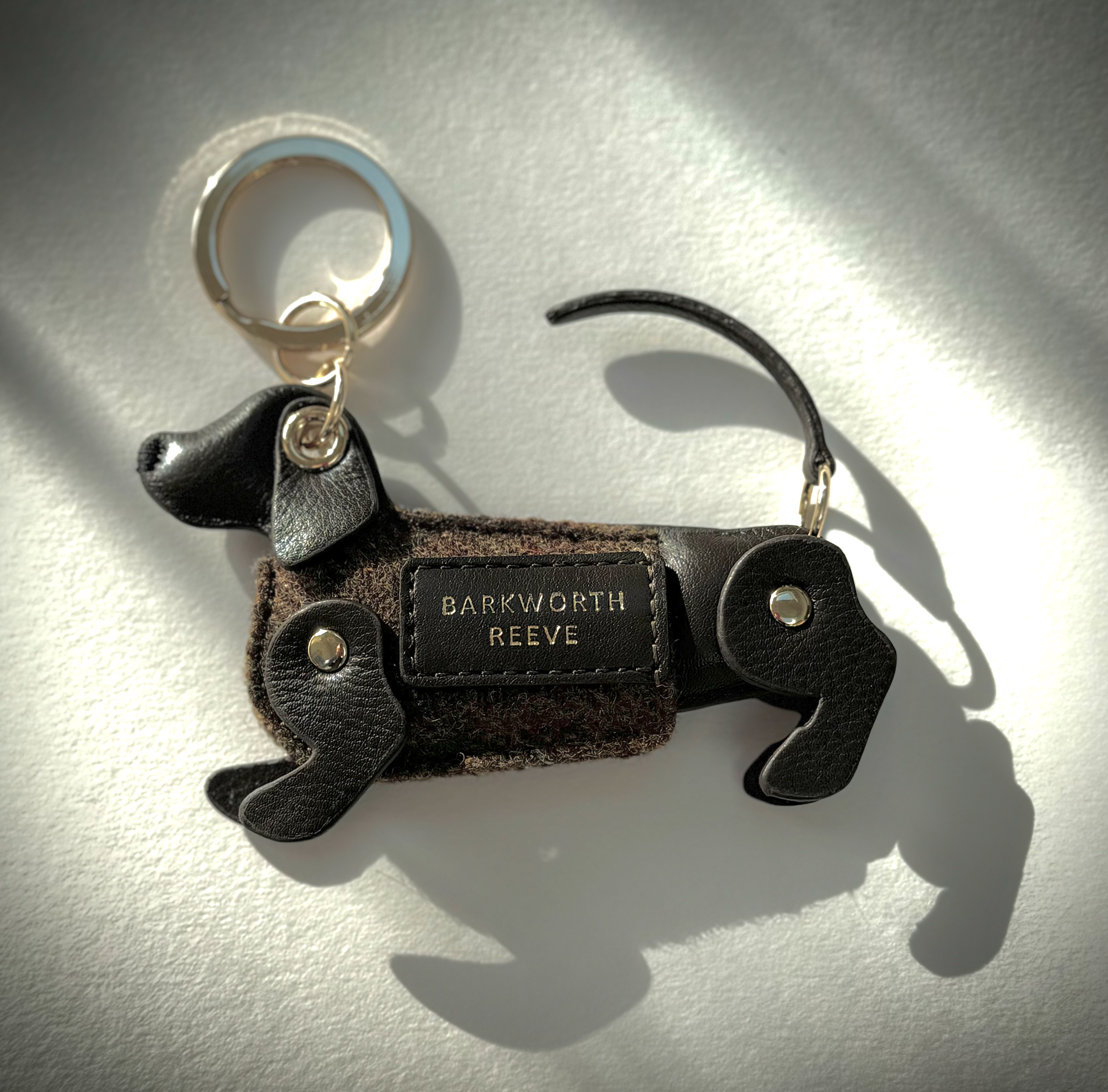 chocolate brown leather dachshund keyring, with tweed coat and gold keyring split ring with shadow lighting